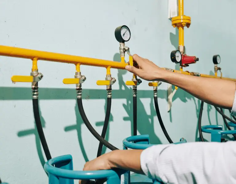 Hand adjusting yellow pipe valve.